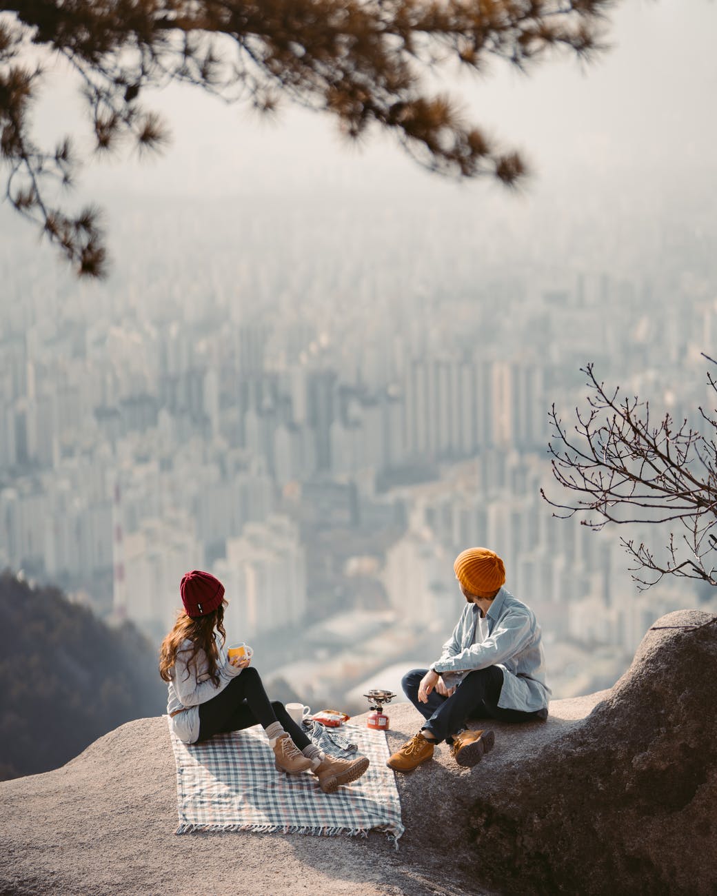 man and woman sitting on rock